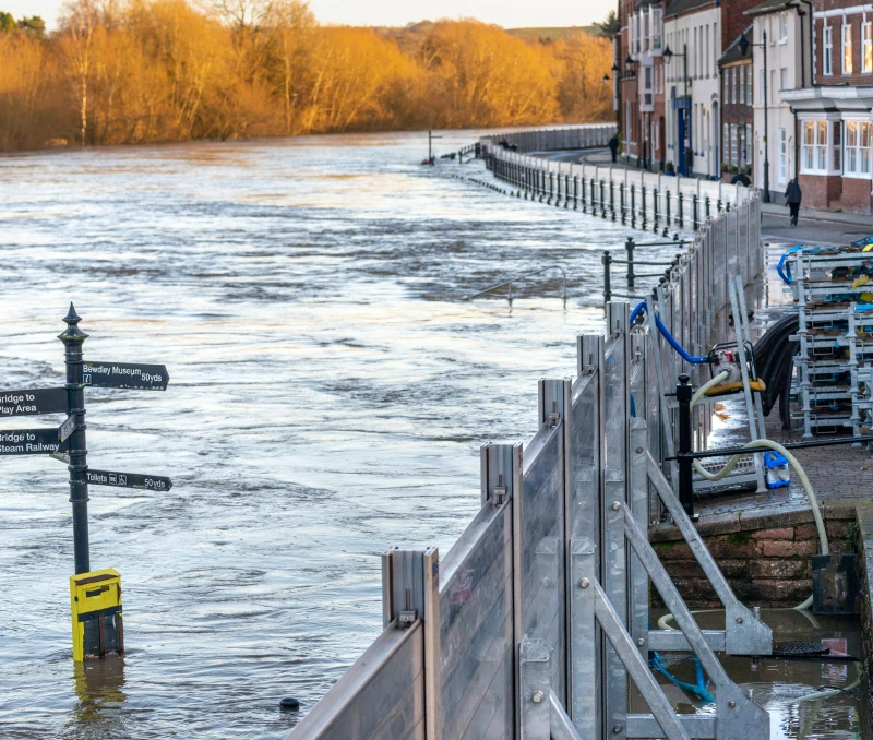 Rising river water near buildings and barricades
